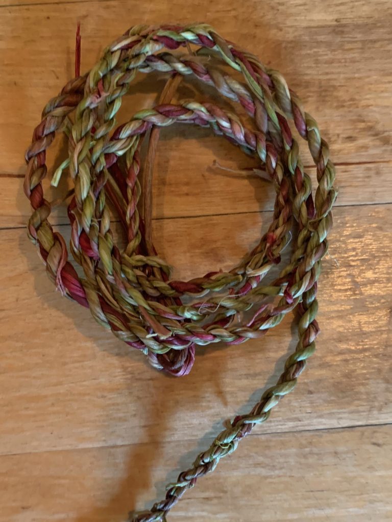 A loop of handmade cordage on a wood table.